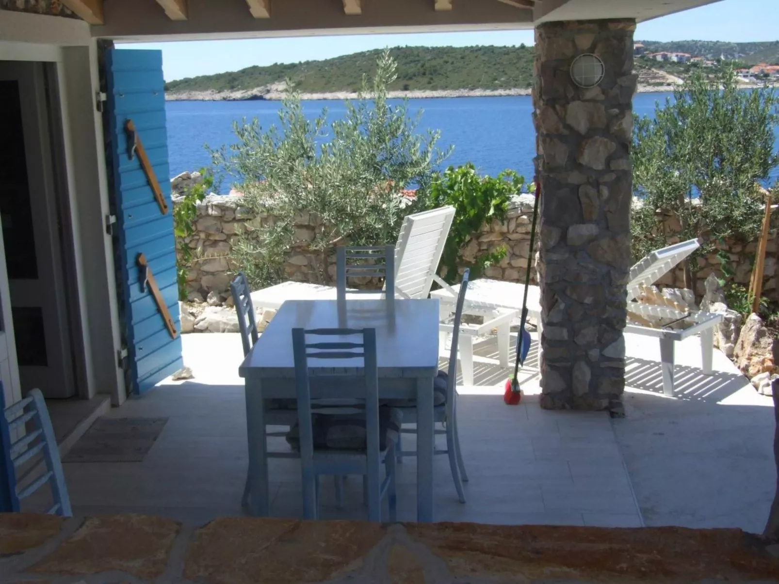 Kleines Steinhaus mit Blick auf das Wasser-Dehors